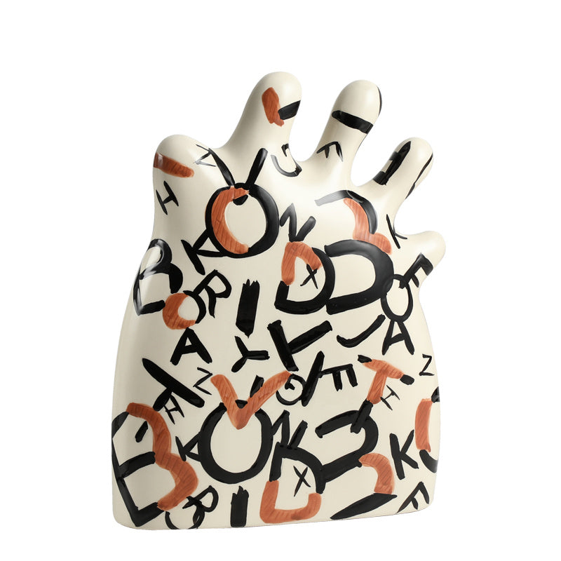 Ceramic hand-shaped object with black and orange text on a white background