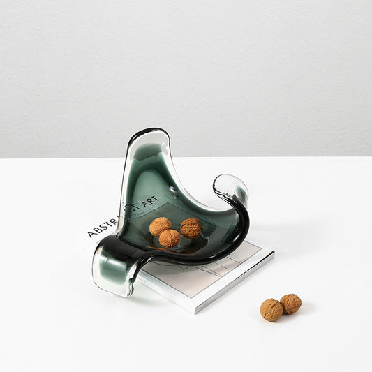 Modern glass nut holder with walnuts on a white surface